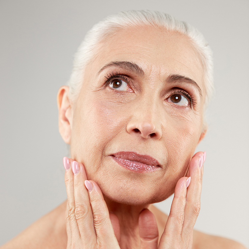 Beauty portrait of an attractive naked elderly woman Skincare expert assessing anti-aging solutions for lines and wrinkles on mature skin.