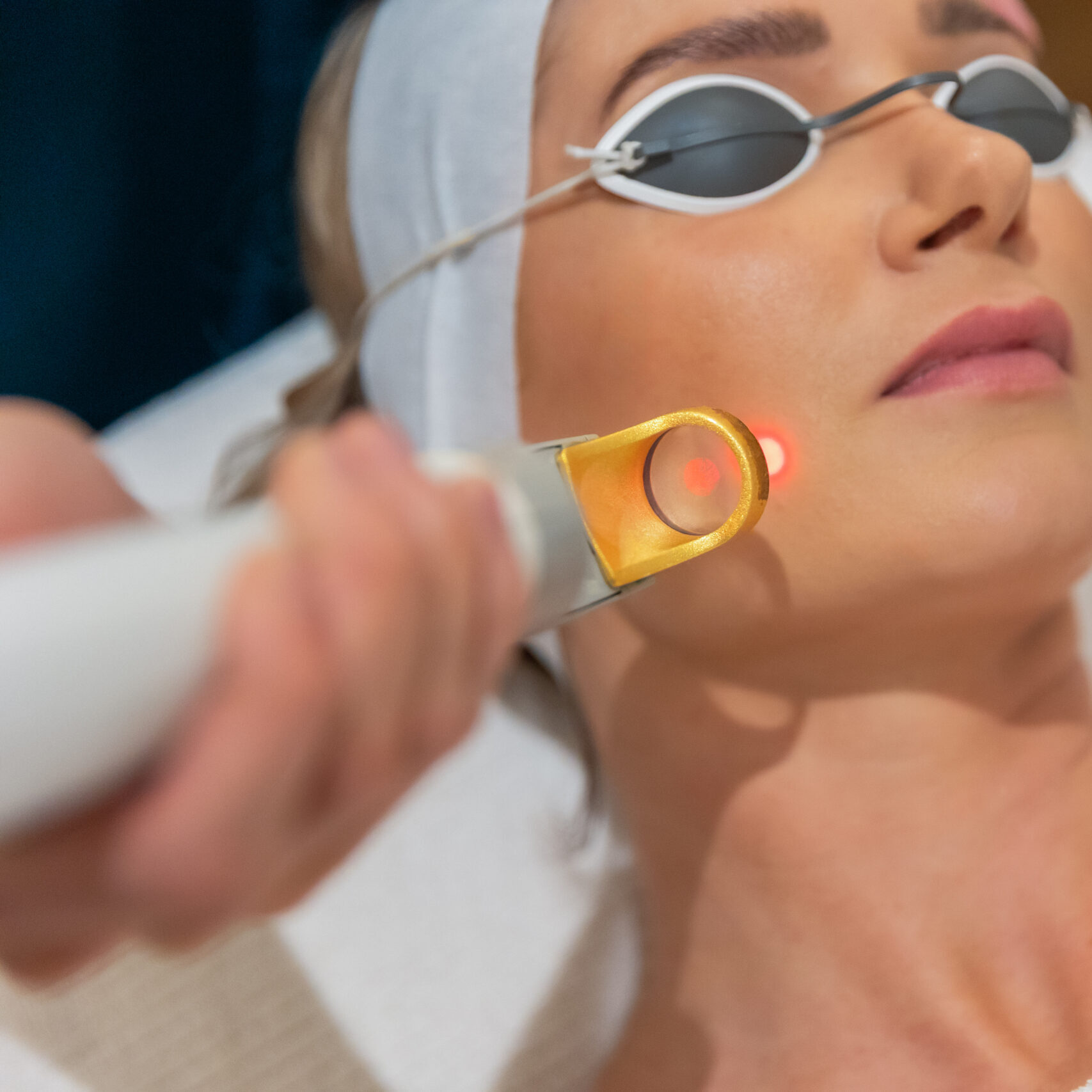 Facial treatment showcasing skin wellness technology with focused red light therapy.