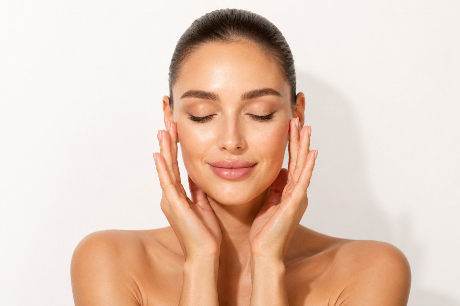 Woman with calm, even-toned skin gently touching her face, illustrating Laser Genesis skin rejuvenation